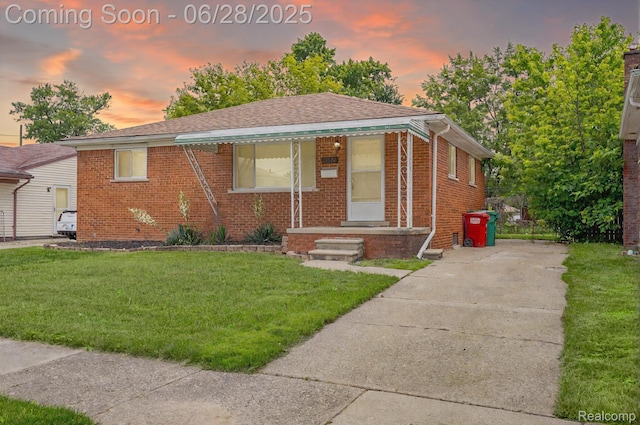 23320 Beechwood Ave, Eastpointe, MI 48021 - bungalow featuring brick siding, a lawn, driveway, and roof with shingles