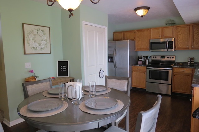 3577 Greenly Ct, Holland, MI 49424 - kitchen with appliances with stainless steel finishes, dark countertops, brown cabinetry, and dark wood-style floors