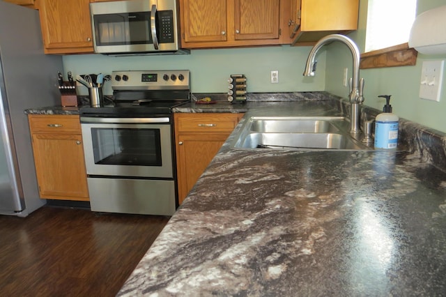 3577 Greenly Ct, Holland, MI 49424 - kitchen featuring appliances with stainless steel finishes, brown cabinetry, and dark wood-type flooring