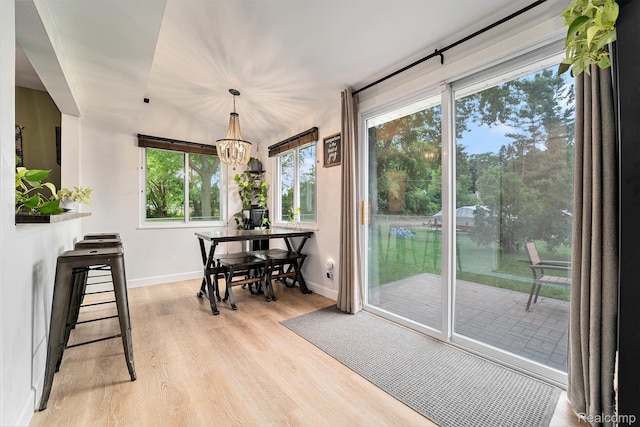 5690 Corunna Ave, Clarkston, MI 48346 - dining space featuring light wood-style floors, plenty of natural light, and a chandelier