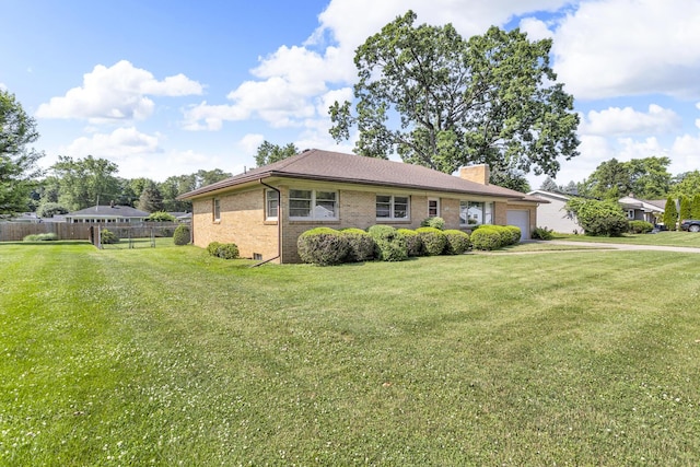 1515 Kensington Dr, Jackson, MI 49203 - single story home featuring a garage, a chimney, and brick siding