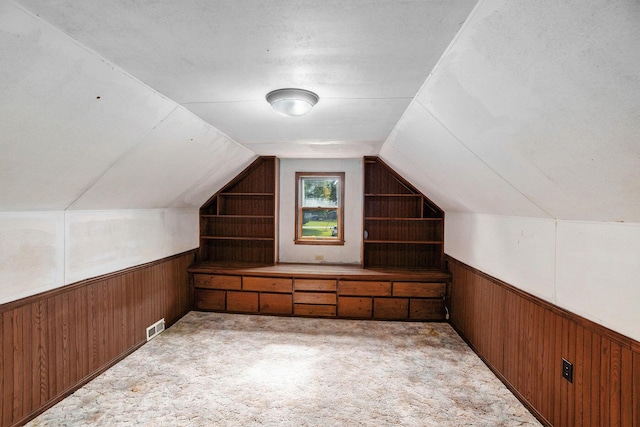 863 E Wilcox Ave, White Cloud, MI 49349 - additional living space with wood walls, wainscoting, vaulted ceiling, and carpet