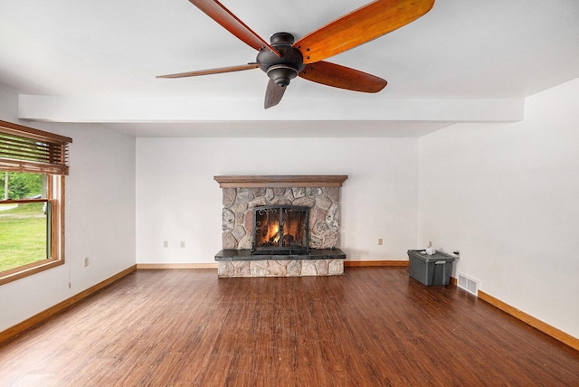 863 E Wilcox Ave, White Cloud, MI 49349 - unfurnished living room featuring wood finished floors, a ceiling fan, and a stone fireplace