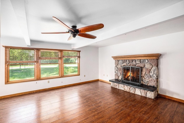 863 E Wilcox Ave, White Cloud, MI 49349 - unfurnished living room with beamed ceiling, a ceiling fan, wood finished floors, and a stone fireplace