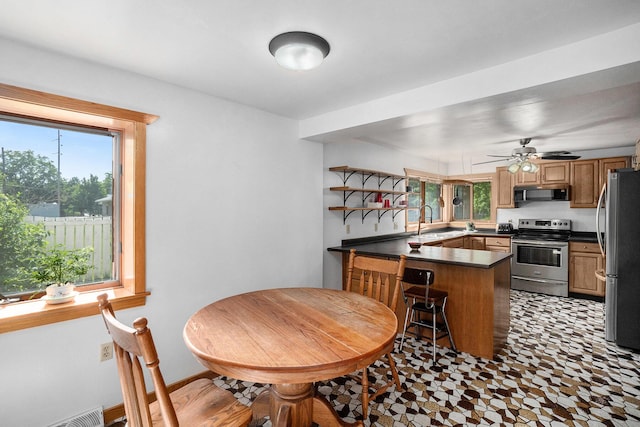 863 E Wilcox Ave, White Cloud, MI 49349 - kitchen with appliances with stainless steel finishes, a peninsula, dark countertops, open shelves, and ceiling fan