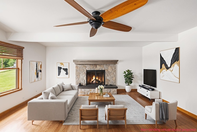 863 E Wilcox Ave, White Cloud, MI 49349 - living area featuring wood finished floors, a ceiling fan, a stone fireplace, and beam ceiling