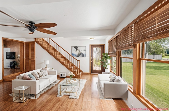 863 E Wilcox Ave, White Cloud, MI 49349 - living room featuring ceiling fan, stairway, and wood finished floors