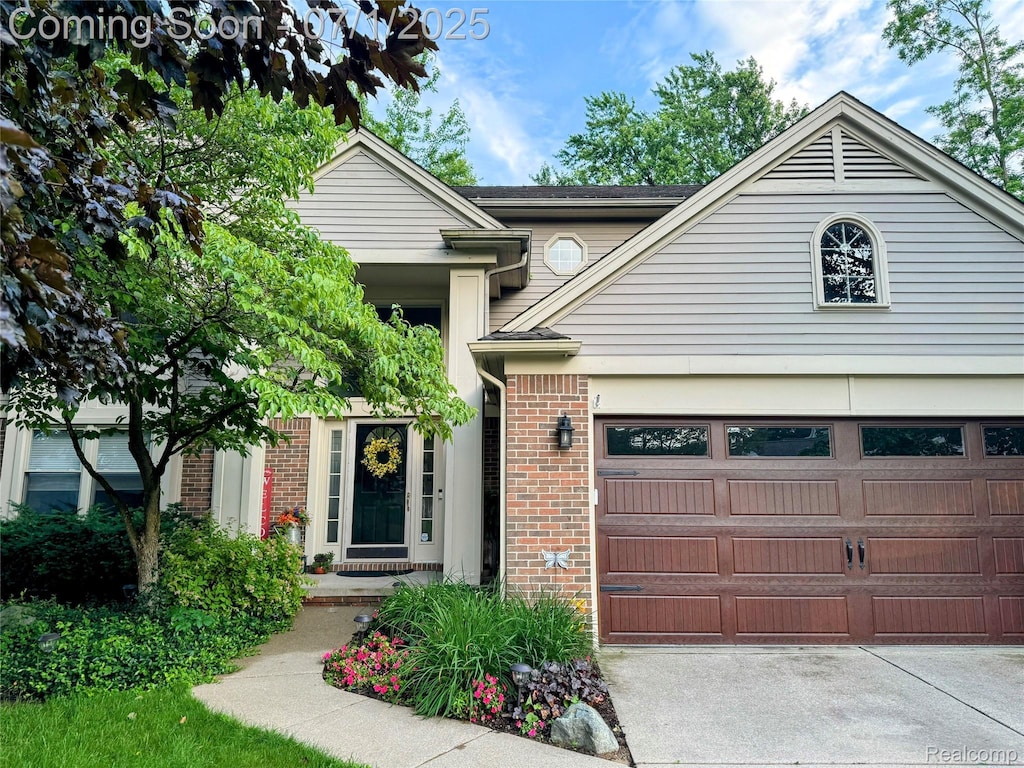 7320 Willow Oak Dr, West Bloomfield, MI 48324 - view of front of home featuring brick siding, driveway, and a garage