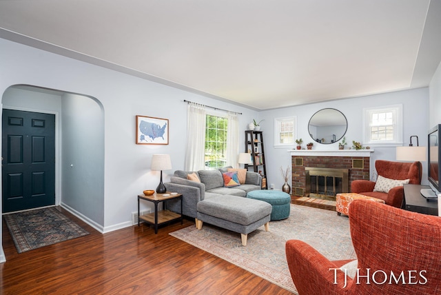 1545 Fuller Ave NE, Grand Rapids, MI 49505 - living room featuring dark wood-style floors, arched walkways, and a fireplace