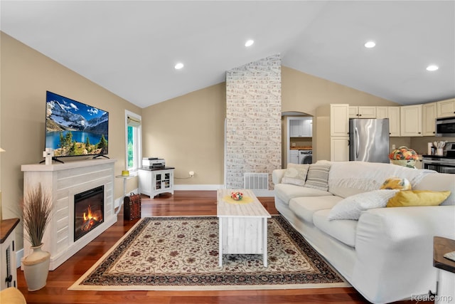 8320 Lagoon St, Commerce Twp, MI 48382 - living area featuring wood finished floors, a glass covered fireplace, arched walkways, washer and clothes dryer, and recessed lighting