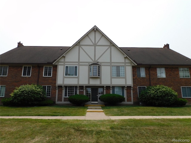 30268 Southfield Rd Unit 229, Southfield, MI 48076 - tudor house featuring brick siding, a front lawn, and a shingled roof