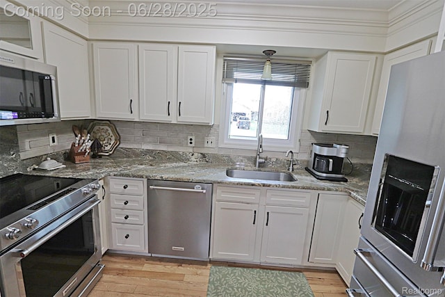 1640 High Pointe Dr, Commerce Twp, MI 48390 - kitchen featuring appliances with stainless steel finishes, white cabinetry, tasteful backsplash, and crown molding