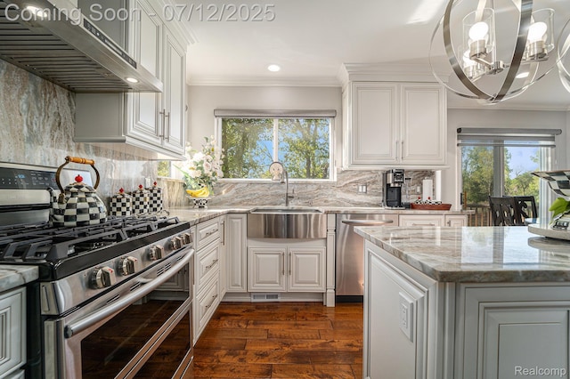 7590 Acorn Hill Ct, West Bloomfield, MI 48323 - kitchen with appliances with stainless steel finishes, under cabinet range hood, dark wood-style floors, a chandelier, and light stone countertops