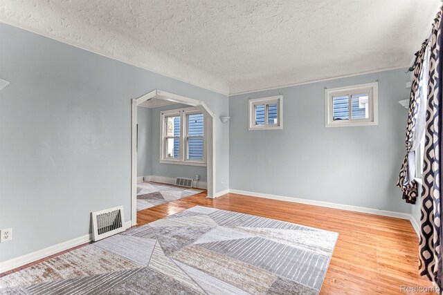 1518 Austin Ave, Lincoln Park, MI 48146 - spare room featuring arched walkways, a textured ceiling, wood finished floors, and crown molding