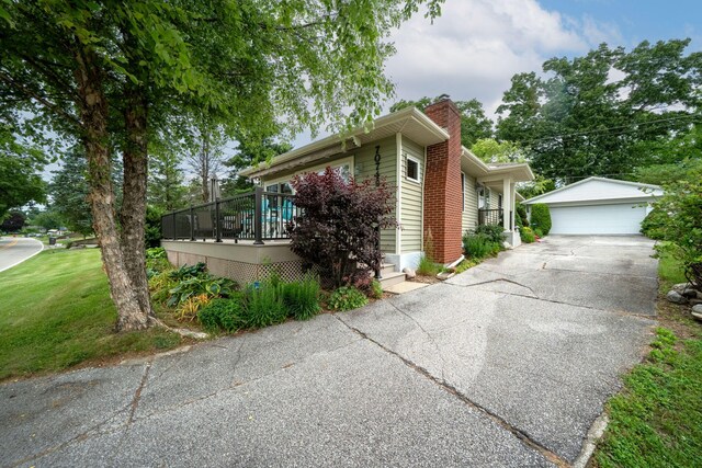 70749 Sunset Blvd, Union, MI 49130 - view of side of home with a chimney, an outbuilding, a garage, and a lawn