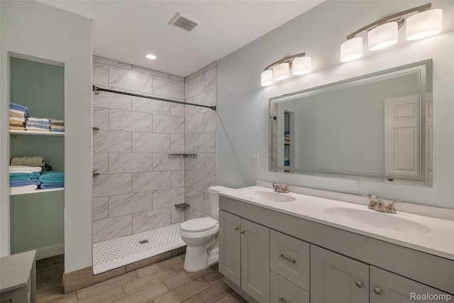 6590 Swartout Rd, Clay, MI 48001 - bathroom with double vanity, tiled shower, wood tiled floors, and recessed lighting