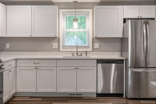6590 Swartout Rd, Clay, MI 48001 - kitchen with stainless steel appliances, white cabinetry, light countertops, hanging light fixtures, and dark wood-style flooring