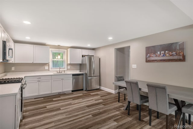 6590 Swartout Rd, Clay, MI 48001 - kitchen with appliances with stainless steel finishes, wood finished floors, light countertops, recessed lighting, and white cabinets