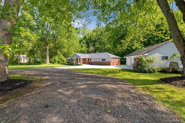 6590 Swartout Rd, Clay, MI 48001 - view of front facade with driveway, brick siding, a front yard, an outbuilding, and a garage