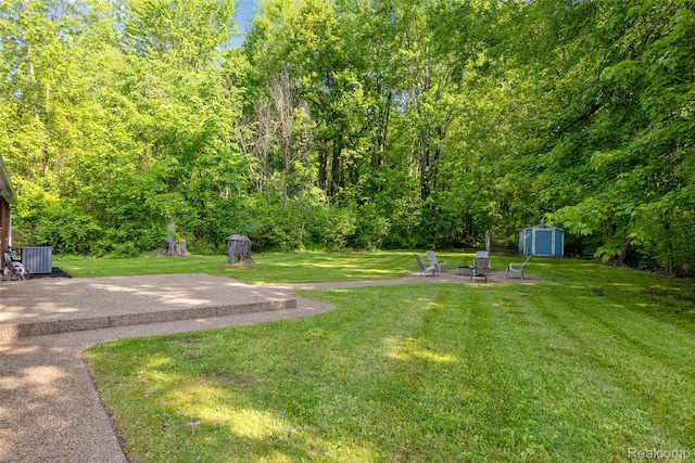 6590 Swartout Rd, Clay, MI 48001 - view of green lawn with a storage shed and a patio