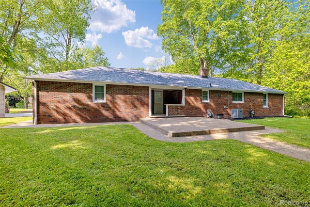6590 Swartout Rd, Clay, MI 48001 - rear view of house with a patio area, a yard, brick siding, and a shingled roof