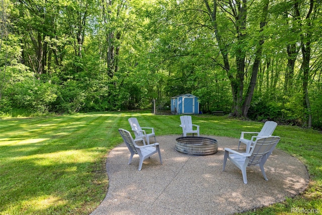 6590 Swartout Rd, Clay, MI 48001 - view of patio with a storage unit, a fire pit, and a view of trees