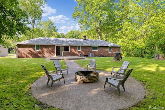 6590 Swartout Rd, Clay, MI 48001 - rear view of property featuring an outdoor fire pit, brick siding, a lawn, and a patio area