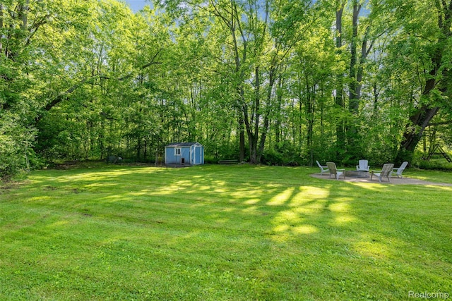 6590 Swartout Rd, Clay, MI 48001 - view of grassy yard with a shed, a fire pit, and a patio area