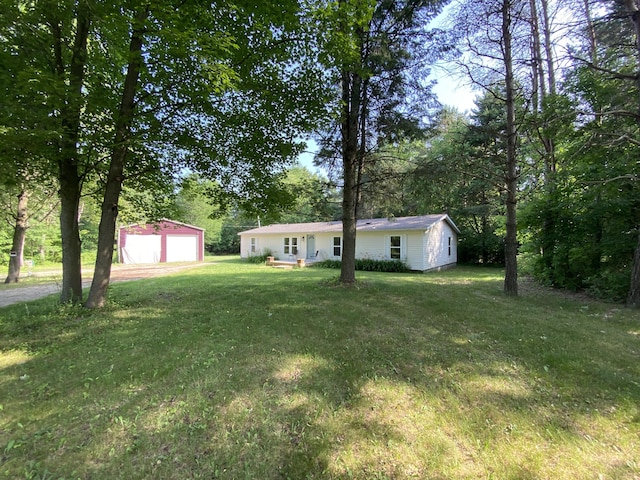 6317 E 76th St, Newaygo, MI 49337 - view of grassy yard with a detached garage, an outdoor structure, and driveway