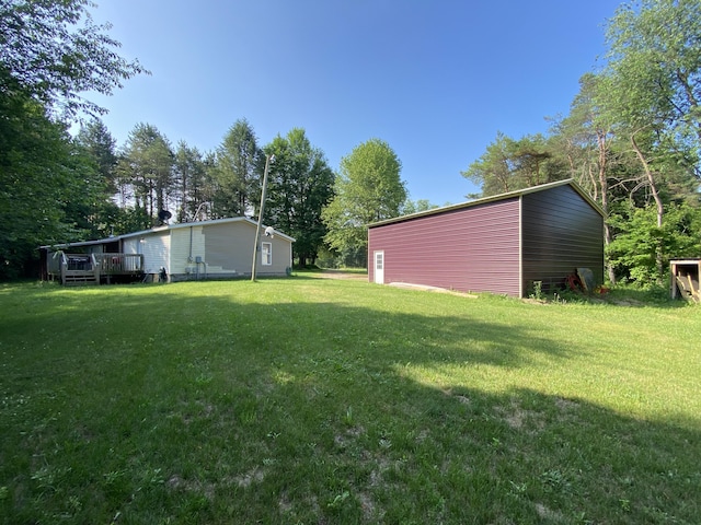 6317 E 76th St, Newaygo, MI 49337 - view of green lawn featuring a deck, view of scattered trees, and an outdoor structure