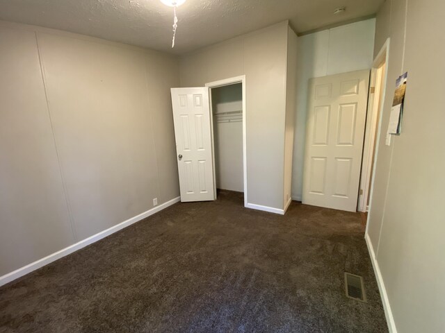 6317 E 76th St, Newaygo, MI 49337 - unfurnished bedroom featuring dark colored carpet, a closet, and a textured ceiling