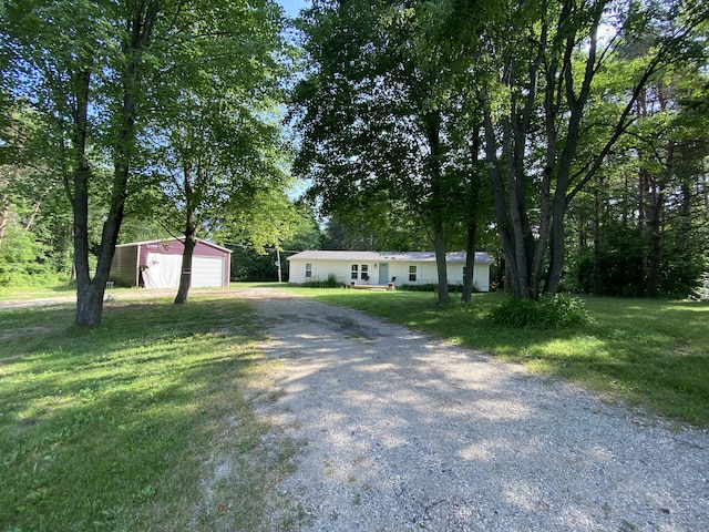 6317 E 76th St, Newaygo, MI 49337 - view of front of home featuring driveway, an outbuilding, a front yard, and a detached garage