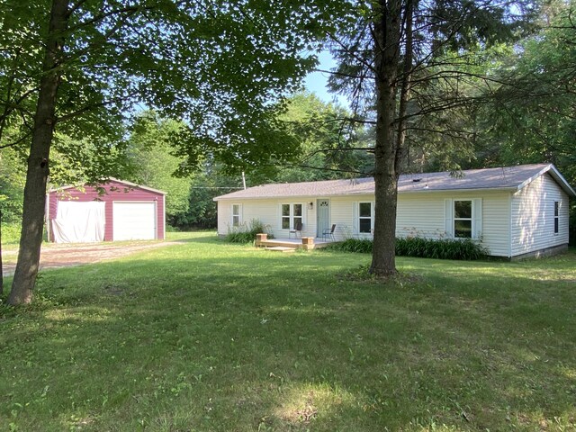 6317 E 76th St, Newaygo, MI 49337 - back of property with a garage, an outbuilding, a lawn, and dirt driveway