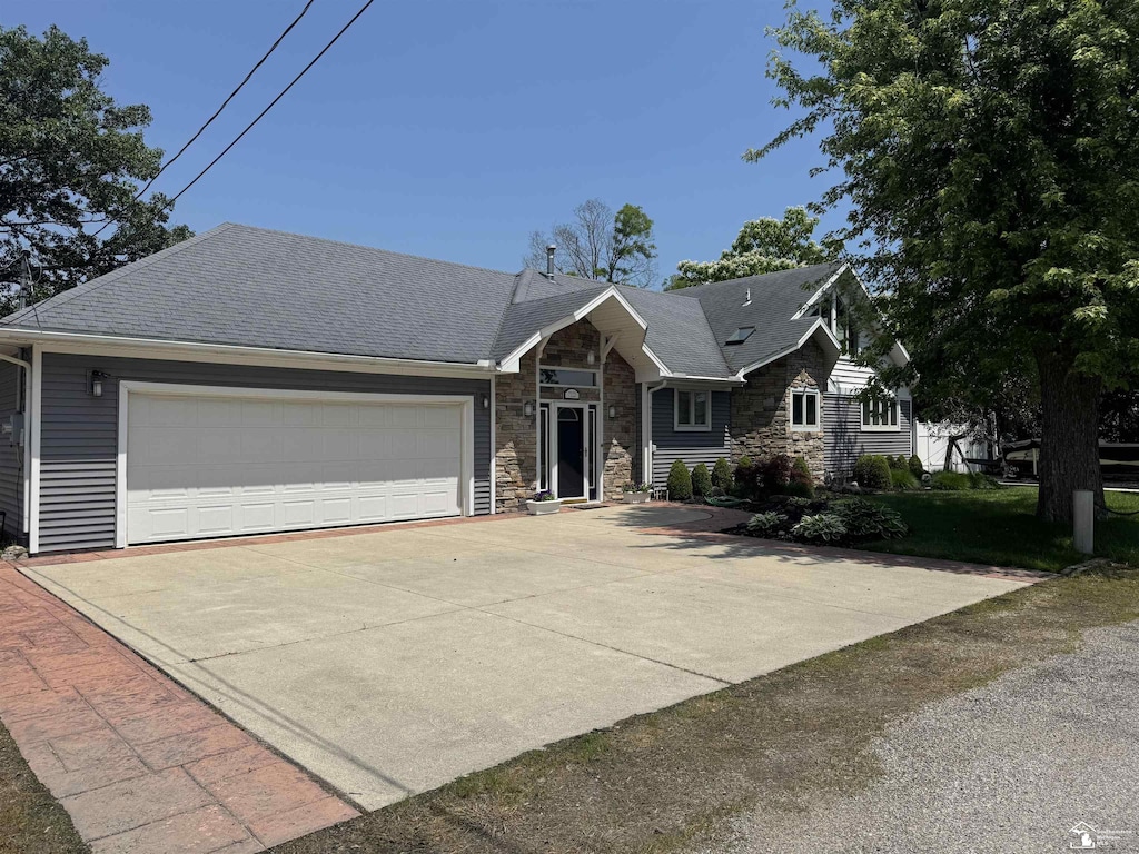 7322 Forrest Ln, Newport, MI 48166 - view of front facade featuring stone siding, a garage, and driveway