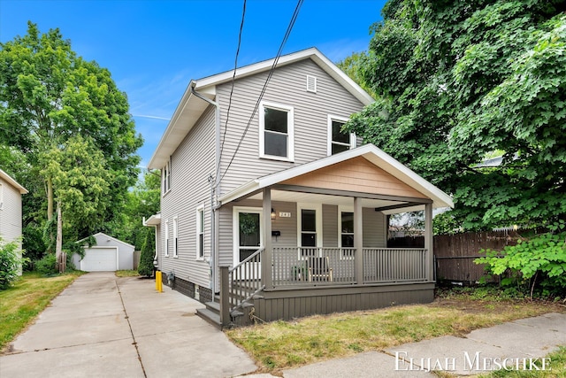 243 Page St NE, Grand Rapids, MI 49505 - view of front of home featuring covered porch, an outbuilding, a detached garage, and concrete driveway