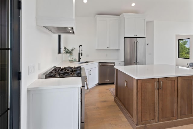 6581 Timpson Ave SE, Alto, MI 49302 - kitchen with appliances with stainless steel finishes, recessed lighting, light wood finished floors, white cabinets, and a kitchen island