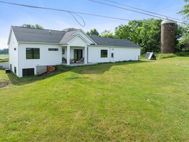 6581 Timpson Ave SE, Alto, MI 49302 - rear view of property with board and batten siding, a lawn, a patio area, and a shingled roof