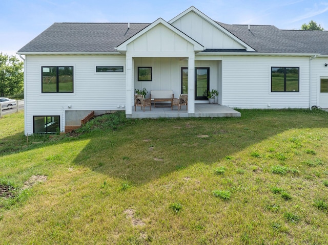6581 Timpson Ave SE, Alto, MI 49302 - back of property featuring board and batten siding, a lawn, roof with shingles, and a patio