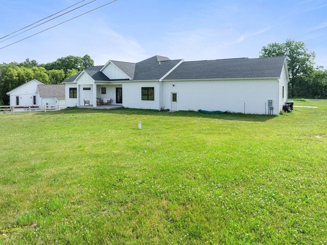 6581 Timpson Ave SE, Alto, MI 49302 - back of property featuring a lawn, a patio, and a shingled roof