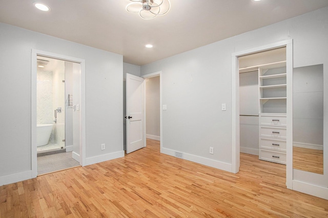 3365 Circle Dr, Saint Joseph, MI 49085 - unfurnished bedroom featuring light wood-style flooring, a spacious closet, recessed lighting, ensuite bathroom, and a closet