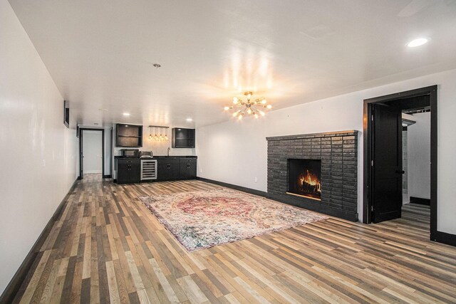 3365 Circle Dr, Saint Joseph, MI 49085 - living area featuring beverage cooler, wood finished floors, a chandelier, a fireplace, and recessed lighting