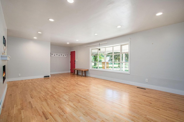 3365 Circle Dr, Saint Joseph, MI 49085 - unfurnished living room featuring wood finished floors, recessed lighting, and a warm lit fireplace