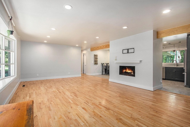 3365 Circle Dr, Saint Joseph, MI 49085 - unfurnished living room with recessed lighting, light wood-style flooring, and a warm lit fireplace