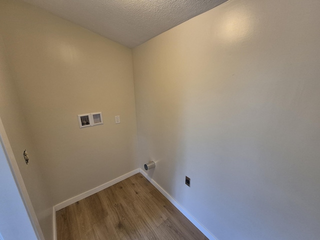 17324 11 Mile Rd, Leroy, MI 49655 - laundry room featuring electric dryer hookup, wood finished floors, washer hookup, and a textured ceiling