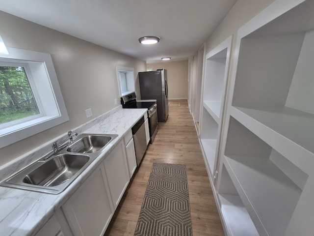 17324 11 Mile Rd, Leroy, MI 49655 - kitchen featuring appliances with stainless steel finishes, light wood finished floors, light countertops, and white cabinetry
