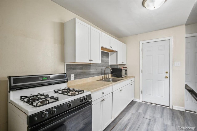 1771 E George Ave, Hazel Park, MI 48030 - kitchen with gas stove, stainless steel microwave, white cabinets, light countertops, and wood finished floors