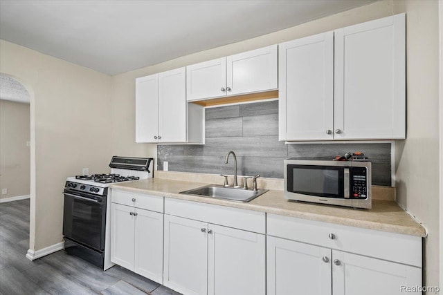 1771 E George Ave, Hazel Park, MI 48030 - kitchen with stainless steel microwave, black gas stove, arched walkways, white cabinets, and light countertops