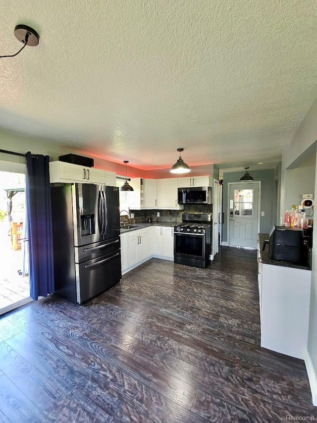 4383 Eagle Ln, Burton, MI 48519 - kitchen with appliances with stainless steel finishes, a textured ceiling, white cabinets, dark wood-style flooring, and dark countertops