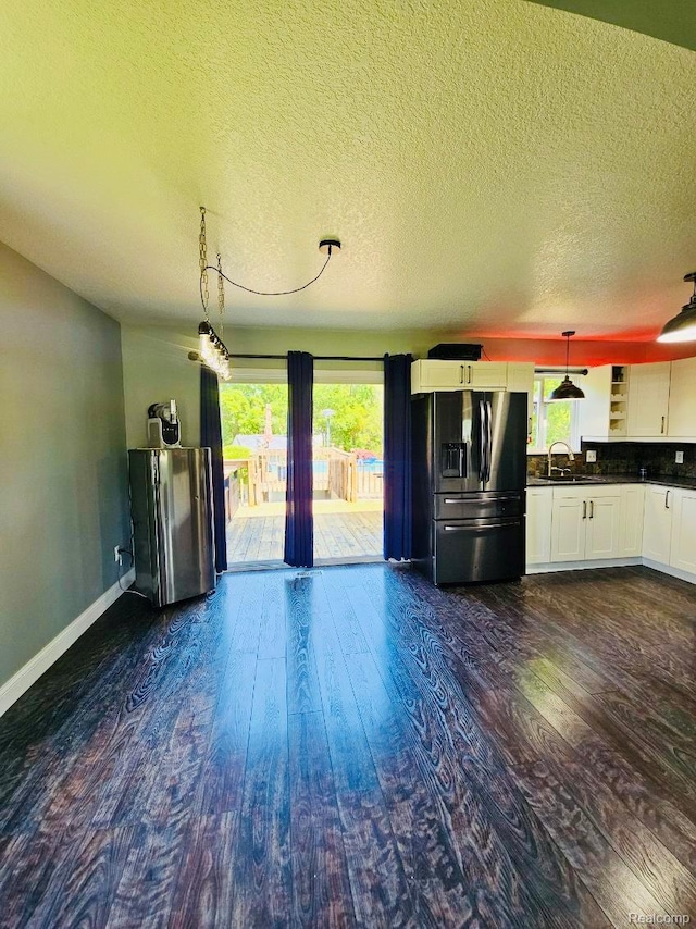 4383 Eagle Ln, Burton, MI 48519 - unfurnished living room featuring plenty of natural light, dark wood-style flooring, and a textured ceiling