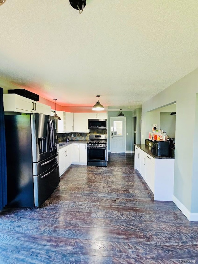 4383 Eagle Ln, Burton, MI 48519 - kitchen featuring stainless steel appliances, dark wood-type flooring, dark countertops, a textured ceiling, and white cabinetry